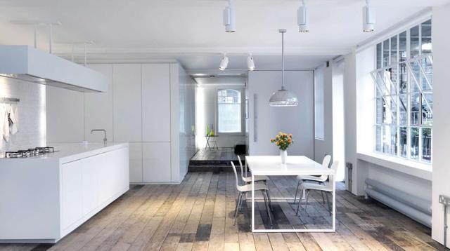 Bermondsey Warehouse Loft (Londres, Reino Unido). Algunos de los espacios funcionales del departamento parecen estar ‘estacionados’ en los ambientes, como la barra que da lugar a la cocina.