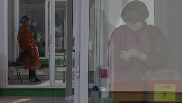 Enfermeras esperan para inocular a personas en un centro de vacunación montado durante la pandemia del nuevo coronavirus en el aeropuerto de Carrasco en Ciudad de la Costa, Canelones en Uruguay el 8 de abril de 2021. (Pablo PORCIUNCULA / AFP).