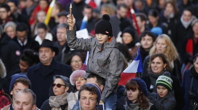1. Un adolescente cargado en hombros muestra un lápiz en señal de solidaridad con los periodistas de la revista Charlie Hebdo. (Foto: Reuters)