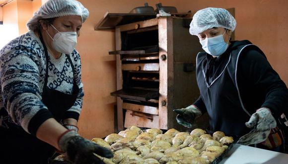 Erika Martinez, a la izquierda, prepara más de 100 presas de pollo en una olla común. Su comedor popular ha alimentado unas 300 personas al día desde mayo. Tamara Merino/Bloomberg
