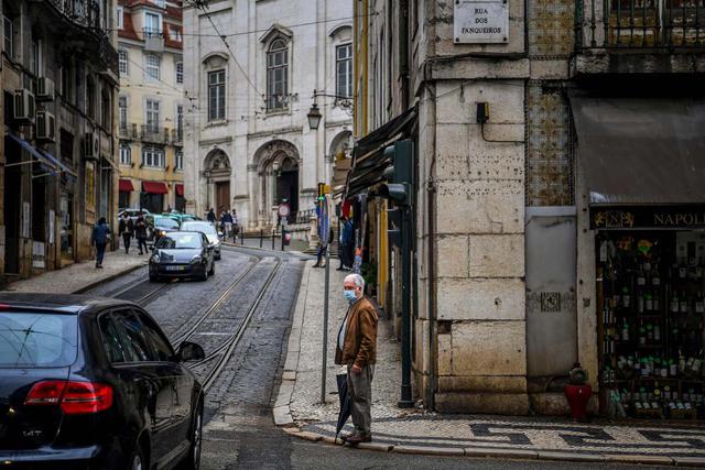Un hombre con mascarilla espera cruzar la calle en el centro de Lisboa (Portugal), el 28 de octubre de 2020. (AFP / PATRICIA DE MELO MOREIRA).