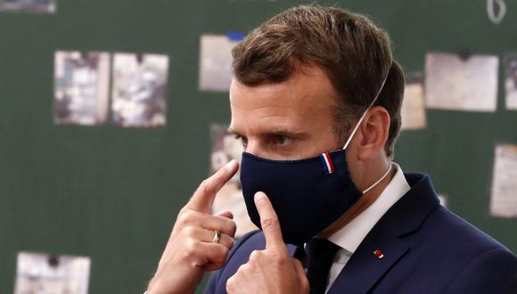 Archivo. El presidente de Francia, Emmanuel Macron, usa una mascarilla protectora mientras habla con los alumnos durante una visita a la escuela primaria Pierre Ronsard en Poissy, al oeste de París. (Foto: LANGSDON / POOL / AFP).