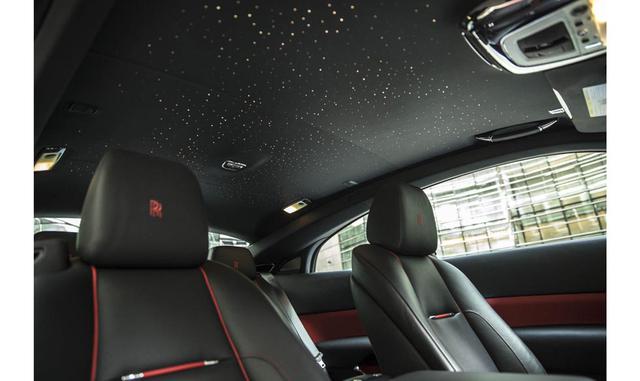 Una vez que uno está adentro, no puede pasar por alto el audaz tapizado carmín y negro de los asientos; el singular reloj Black Badge colocado en el tablero, con manecillas de puntas anaranjadas, y el logo infinito bajo el reloj y entretejido en el asient