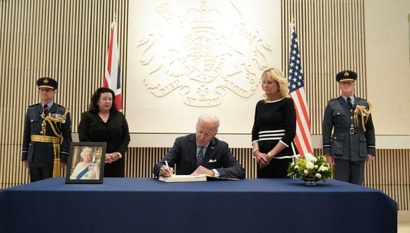 El presidente de EE. UU., Joe Biden, firma el libro de condolencias en la embajada británica en Washington para presentar sus respetos tras la muerte de la reina Isabel II de Gran Bretaña mientras la primera dama, Jill Biden (derecha), y la embajadora británica en EE. UU., Karen Pierce, observan en Washington, DC el 8 de septiembre de 2022. (Foto de Mandel NGAN / AFP)