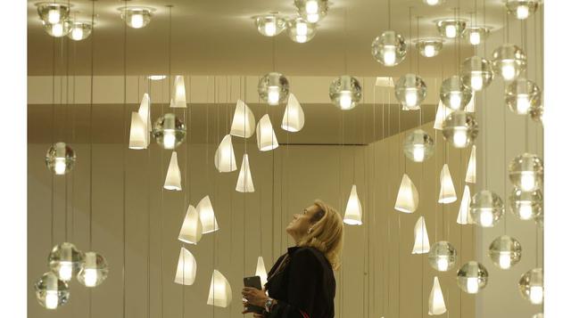 Una mujer aprecia lámparas Bocci en la exhibición de la Feria de Diseño de Milán, Italia, que muestra lo último en mobiliario y diseño de países de todo el mundo. (Foto: AP)
