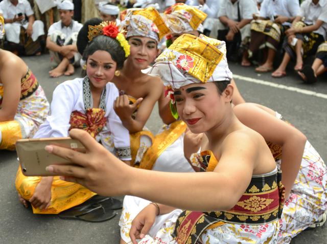 FOTO 11 | Jóvenes de Bali se preparan para participar en un desfile cultural de un festival para celebrar el Año Nuevo en Denpasar. (Foto: AFP)