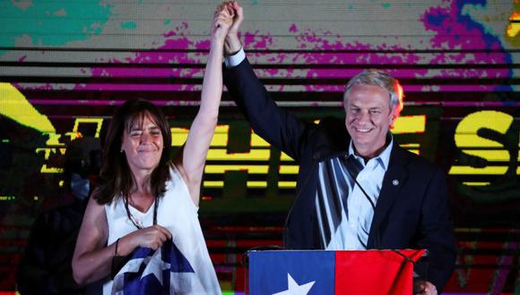 El candidato presidencial chileno José Antonio Kast y su esposa Maria Pia Adriasola Barroilhet levantan la mano mientras habla luego de los resultados parciales de la primera vuelta durante las elecciones presidenciales, en Santiago, Chile. (REUTERS / Ivan Alvarado).