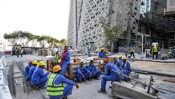 Los constructores migrantes toman un descanso mientras trabajan en un sitio de construcción en Corniche, en Doha, el 24 de noviembre de 2022, durante el torneo de fútbol de la Copa Mundial de Qatar 2022. (Foto de CHANDAN KHANNA / AFP)