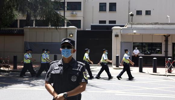 Policías chinos marchando ante el antiguo consulado estadounidense en Chengdu, en la provincia suroccidental china de Sichuan. (Foto: AP/Ng Han Guan)