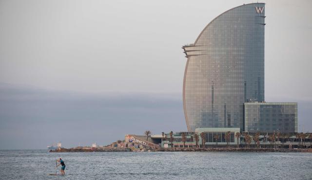Un hombre practica paddle surf en la playa de la Barceloneta en Barcelona, ​​el 8 de mayo de 2020. (AFP / Josep LAGO).