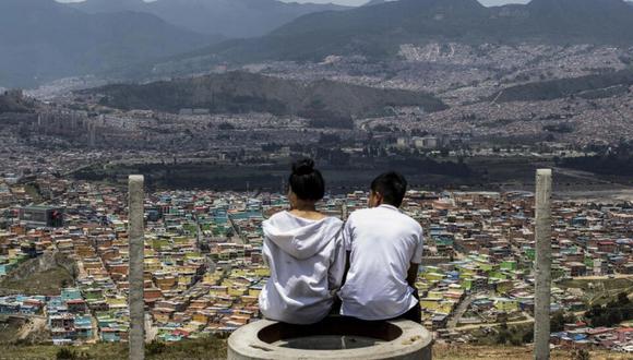 Turistas observan el barrio Ciudad Bolívar, uno de los más pobres de Bogotá, durante un recorrido por la capital colombiana. © Alejandro MARTINEZ / AFP