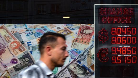 Antes y después de la decisión, la moneda osciló bruscamente, casi un 10% en un solo día y debilitándose hasta 11.3 por dólar por primera vez. (Photo by Yasin AKGUL / AFP)