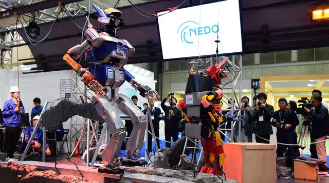 Un robot humanoide HRP – 2 ( L ) , producido por Kawada , camina entre los escombros simulacro esparcidos por el suelo durante una demostración de cómo el robot maniobrar dentro de un área de desastre en la Exposición Anual Internacional Robot en Tokio.