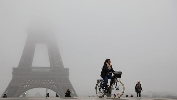 La gente camina cerca de la Torre Eiffel con máscaras protectoras en medio del brote de COVID-19, el nuevo coronavirus, en la explanada de Trocadero en París. (Foto: AFP)