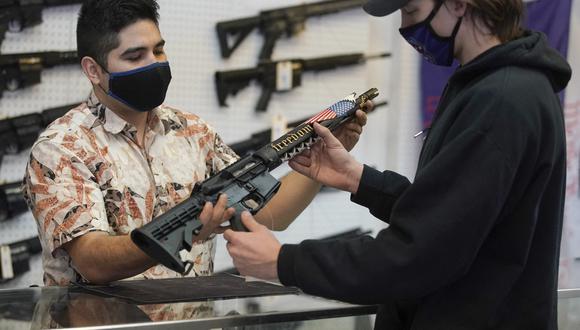 Un cliente observa un rifle de estilo AR-15 hecho a medida en Davidson Defense en Orem, Utah. (GEORGE FREY / AFP).