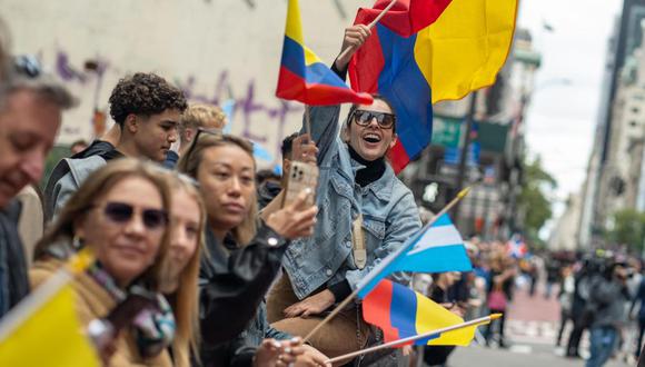Una mujer ondea una bandera colombiana mientras observa el desfile del Día de la Hispanidad hoy, en la Quinta Avenida de Nueva York (EE.UU.). EFE/ Ángel Colmenares