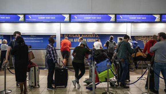 Los viajeros hacen cola en un mostrador de información de SAA (South African Airways) en el Aeropuerto Internacional Tambo en Johannesburgo, Sudáfrica. (Foto: Michele Spatari / AFP)