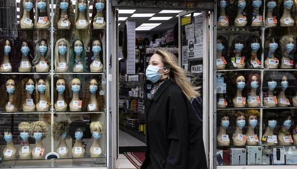 Una mujer camina por la calles de Francia al lado de una tienda de mascarillas. El país europeo es uno de los que más sufre la segunda ola de contagios. (Foto: EFE)
