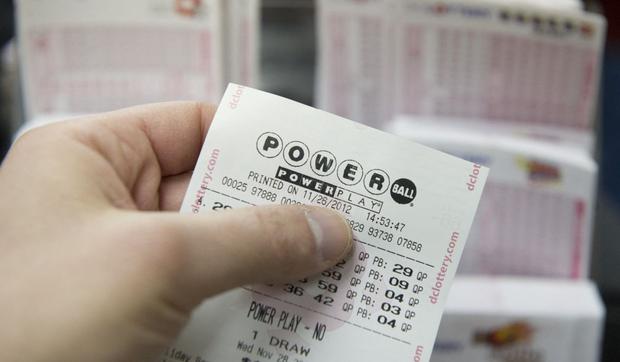 A man checks his Powerball lottery ticket at a store in Washington on November 26, 2012 (Photo: Saul Loeb/AFP)