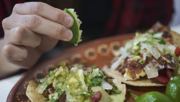 Un comensal exprime un limón sobre tacos en un restaurante en Ciudad Valles, San Luis Potosí, México, el lunes 7 de marzo de 2022.