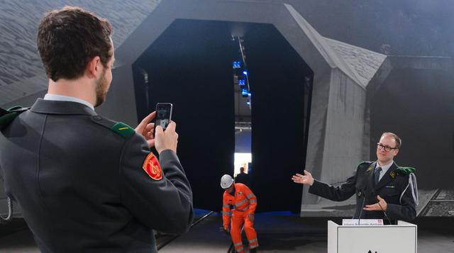 Dos soldados suizos se toman una foto frente a la entrada norte del nuevo túnel ferroviario de base San Gotardo, el más largo del mundo con 57 kilómetros de longitud, que atraviesa los Alpes. (Foto: AFP)