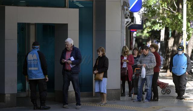 Los jubilados, el sector más vulnerable y con recomendación de quedarse en sus casas, son también los más reacios a manejarse con tarjetas de débito y es muy habitual que prefieran cobrar en efectivo y por ventanilla. (JUAN MABROMATA / AFP).