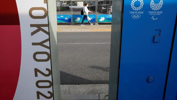 Un transeúnte se ve entre carteles que anuncian los Juegos Olímpicos y Paralímpicos de Tokio 2020, que se han pospuesto hasta 2021 debido al coronavirus (COVID-19), en Tokio, Japón, el 14 de mayo de 2021. (Foto: Reuters/Issei Kato).