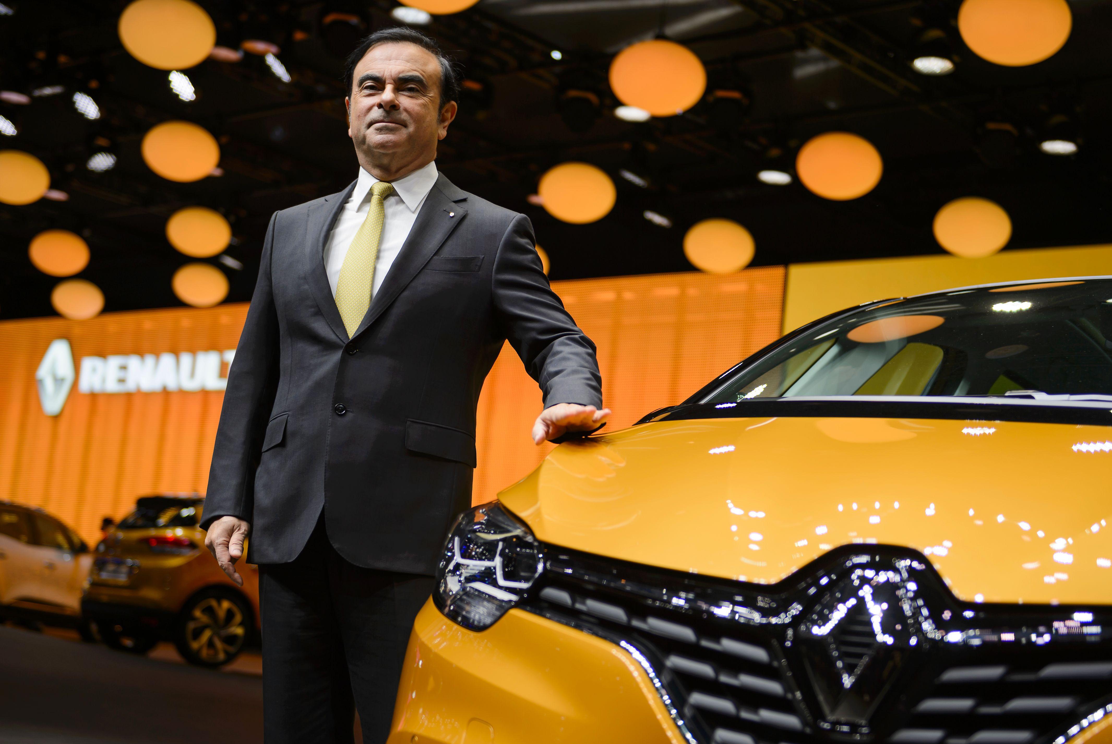 French carmaker Renault CEO Carlos Ghosn poses next to the new Renault Scenic model car at the stand of French carmaker during the press day of the Geneva Motor Show on March 1, 2016 in Geneva. / AFP / FABRICE COFFRINI
