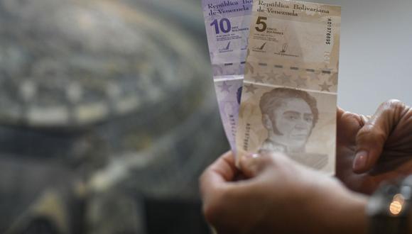 Una persona sostiene billetes de bolívares venezolanos. (Fotógrafo: Carolina Cabral/Bloomberg)