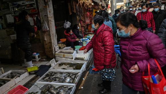 Los clientes compran en un mercado en Wuhan, provincia central china de Hubei, el 19 de enero de 2021. (Foto de Hector RETAMAL / AFP)