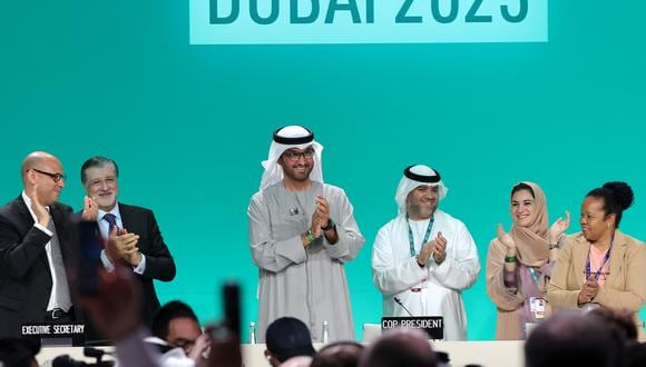 El presidente de la COP28, Sultan Ahmed Al Jaber (C), aplaude entre otros funcionarios antes de una sesión plenaria durante la cumbre climática de las Naciones Unidas en Dubai el 13 de diciembre de 2023. (Foto de Giuseppe CACACE / AFP)