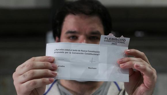 Un hombre sostiene un voto con el rechazo para la nueva Constitución en Chile.