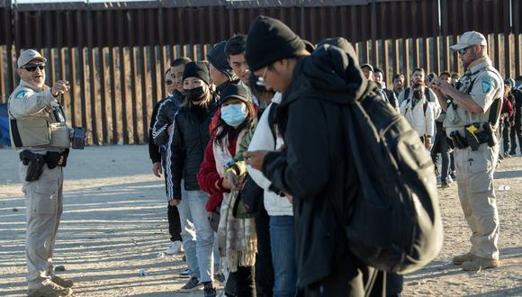 Agentes de la patrulla fronteriza procesan a los migrantes que ingresaron ilegalmente a los EE.UU. antes de llevarlos a un puerto de entrada en Jacumba, California, el 6 de diciembre de 2023 (Foto: Valerie Macon / AFP)