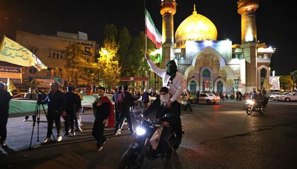Manifestantes ondean la bandera de Irán mientras se reúnen en la Plaza de Palestina en Teherán, después de que Irán lanzara un ataque con drones y misiles contra Israel. (Crédito: Atta Kenare/AFP/Getty Images)