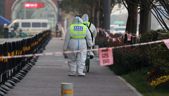 Guardias de seguridad caminando en un área que está bajo restricciones luego de un reciente brote de coronavirus en Xi'an, en la provincia norteña de Shaanxi, en China. (Foto: AFP)
