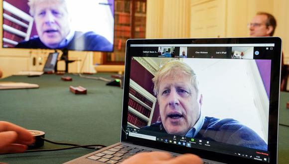 Esta foto del 28 de marzo del 2020, muestra una imagen del primer ministro británico, Boris Johnson, en una pantalla de computadora mientras preside de forma remota una reunión sobre el coronavirus. (Foto: AFP)