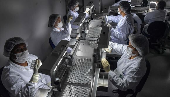 Los empleados trabajan en una máquina llenadora de vacunas contra el COVID-19 en el Serum Institute of India, Pune, India, el jueves 21 de enero de 2021. (Foto: referencial/AFP).