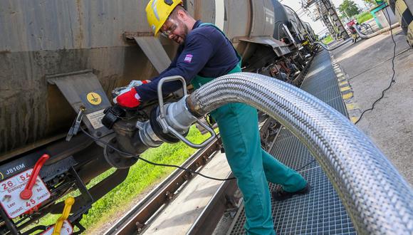 Un trabajador se prepara para recibir un aditivo líquido para la refinación de petróleo de un tren cisterna en la refinería Duna (Danubio) de la compañía húngara MOL ubicada cerca de la ciudad de Szazhalombatta, a unos 30 km al sur de Budapest el 5 de mayo de 2022. (Foto de ATTILA KISBENEDEK / AFP)