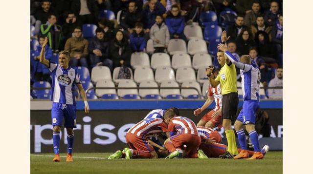 Jugadores del Deportivo y del Atlético asisten a Torres en el campo, tras el fuerte golpe que ha recibido en la cabeza por un choque con Alex Bergantiños.(foto:elpaís).