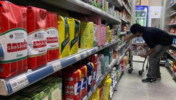Un hombre organiza productos en un supermercado de Buenos Aires, el 16 de septiembre de 2022. (Foto de Luis ROBAYO / AFP)