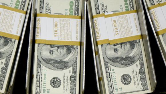 Fajos de billetes de cien dólares pasan por una máquina circuladora en la Oficina de Grabado e Impresión en Washington, D.C.