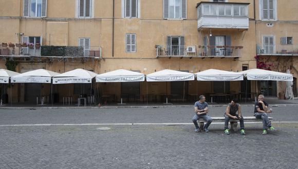 Las personas se sientan frente a un restaurante cerrado en la Piazza Navona Square, en Roma. (AP/Alessandra Tarantino).