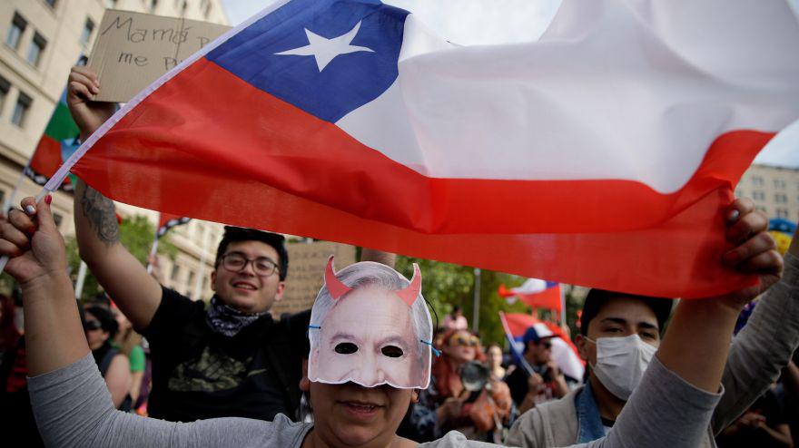 Una manifestante sostiene una bandera de Chile durante una protesta contra el Gobierno del presidente chileno Eduardo Piñera este sábado frente al Palacio La Moneda, sede de la presidencia, en Santiago (Chile). EFE/Fernando Bizerra Jr