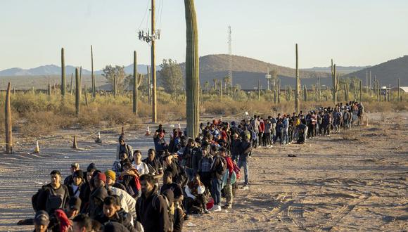 Migrantes hacen fila afuera de un centro de la Border Patrol en la frontera entre México y Estados Unidos.