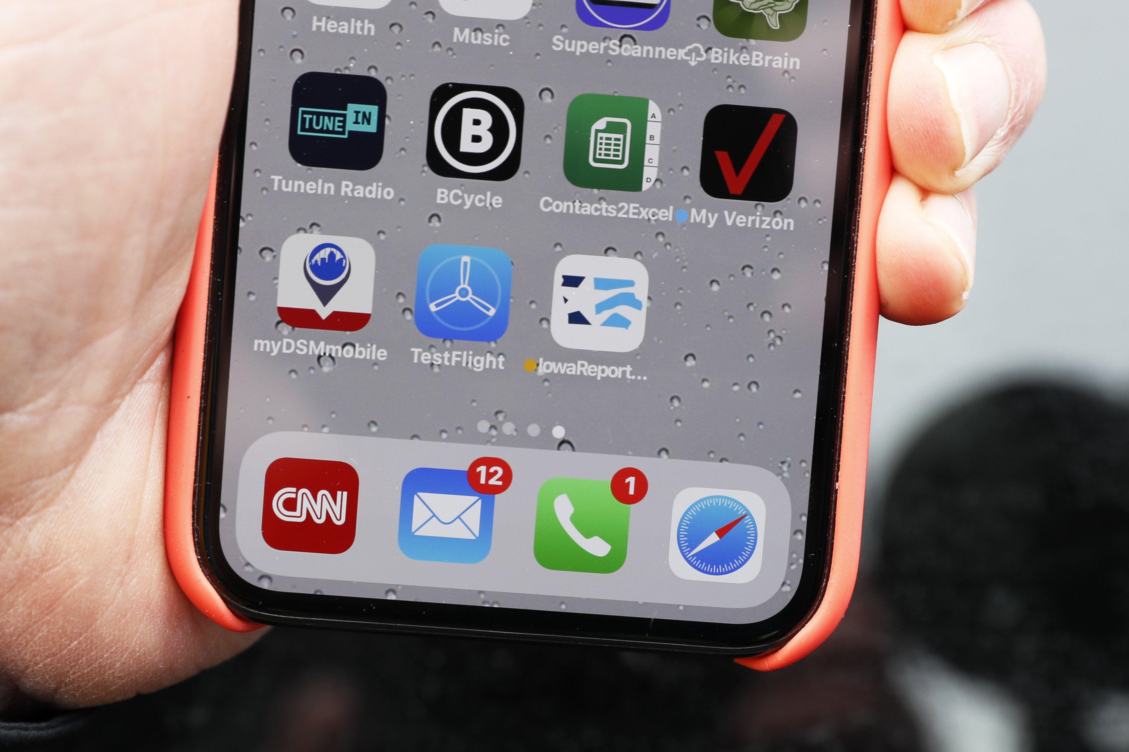 Un líder demócrata de Iowa sostiene su iPhone que muestra el ícono de la aplicación sobre el caucus del Partido Demócrata. (Foto AP / Charlie Neibergall).