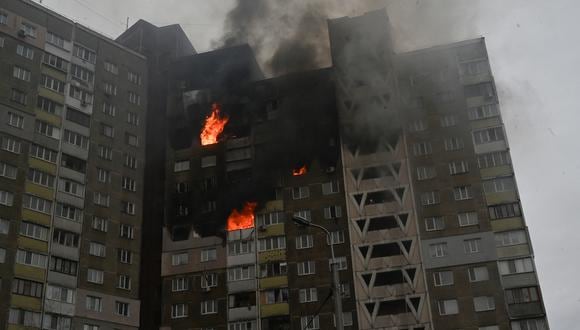 Esta fotografía tomada en Kiev el 7 de febrero de 2024 muestra un edificio en llamas y dañado como resultado de un ataque con misiles, en medio de la invasión rusa de Ucrania. (Foto: AFP)