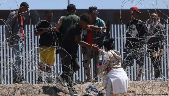 Migrantes rompen la valla de alambre de púas para cruzar hacia Estados Unidos. (Foto: AFP)