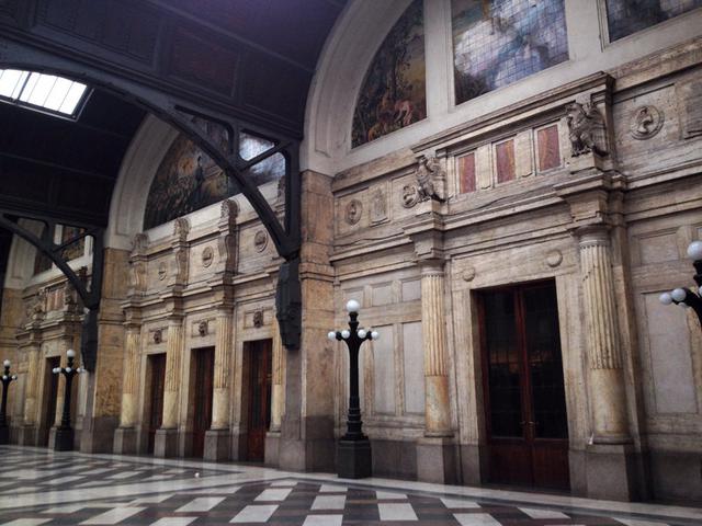 FOTO 6 |  El pabellón real de la Estación Central de Milán- Italia. Cada día más de 300,000 personas pasan por la Stazione Centrale, la principal estación de trenes de Milán. La mayoría desconoce que una serie de puertas cerradas de la estación dan acceso a la sala más lujosa y exclusiva del edificio, el Padiglione Reale, o Royal Pavilion, una sala de espera exclusiva construida para la familia real de Italia en la década de 1920.
A pesar de que la monarquía fue desterrada en Italia inmediatamente después de la Segunda Guerra Mundial, la sala de espera real todavía está allí. El nivel del suelo tiene un par de habitaciones desnudas y sirve como antesala al nivel superior. Una suntuosa habitación está en el primer piso, al mismo nivel que las vías del tren. Hay interiores de mármol en diferentes estilos arquitectónicos, esculturas de los emblemas reales, muebles elegantes proporcionados por los mejores diseñadores de interiores de la época, y un balcón con una vista en la plaza pública de abajo.