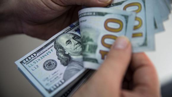 Un hombre cuenta un fajo de billetes de cien dólares estadounidenses en Turquía. Fotógrafo: Bloomberg Creative Photos/Bloomberg