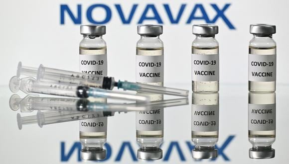 (FILES) This file illustration picture shows vials with Covid-19 Vaccine stickers attached and syringes with the logo of US biotech company Novavax, on November 17, 2020. - Europe's medicines watchdog on December 20, 2021, approved a Covid jab by US-based Novavax, which uses a more conventional technology that the biotech firm hopes will reduce vaccine hesitancy. (Photo by JUSTIN TALLIS / AFP)